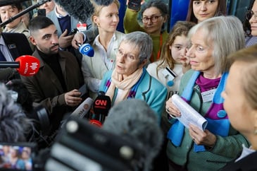 White woman talking to media